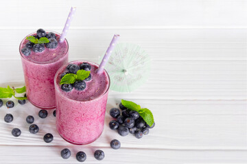 Blueberry Juice smoothies drink in a glass drink purple colorful fruit juice milkshake blend beverage healthy high protein the taste yummy in glass on white wood background.
