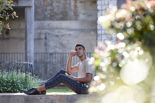 Young Indigenous Australian man reading outdoors