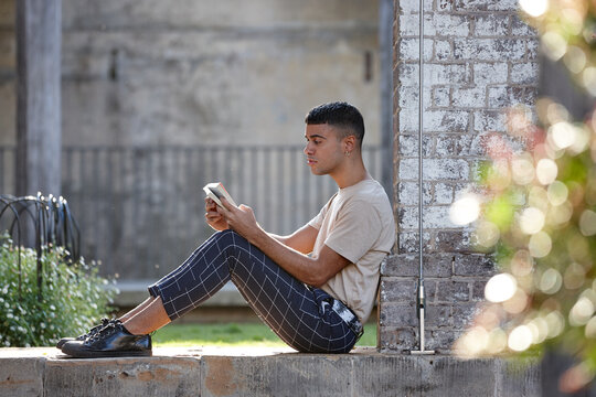 Young Indigenous Australian man reading outdoors