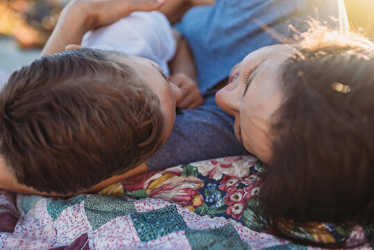 Mother and young son outdoors on quilt