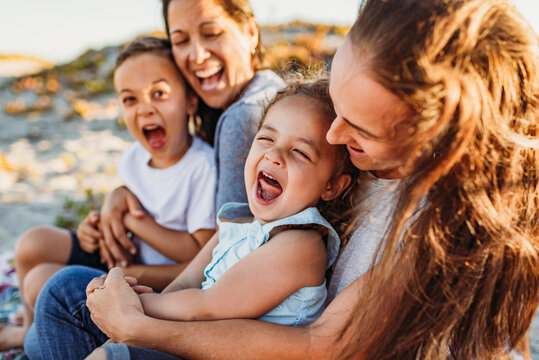 Laughing family with two moms at beach