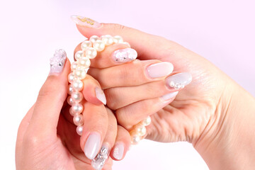 パールのネックレスを持つ女性の手