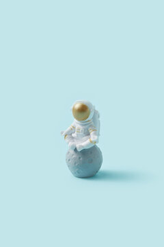 Toy astronaut meditating on moon