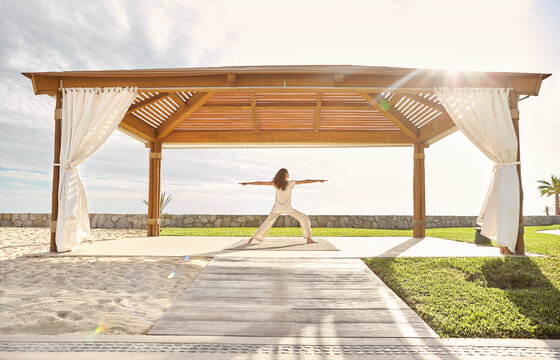 Woman doing yoga pose at luxury hotel spa on beach