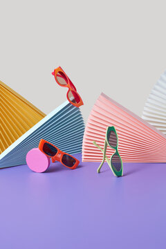 Colorful sunglasses and hand fans indoors