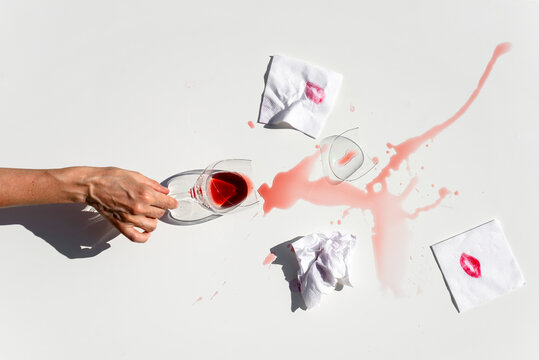 Woman touching broken wineglass at table