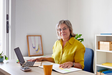 Happy mature businesswoman with laptop