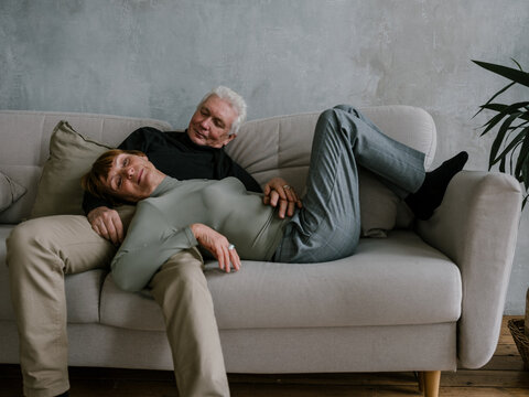 Senior couple resting on the couch having fun