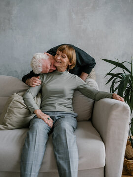 Senior man kissing woman at the neck laughing shy