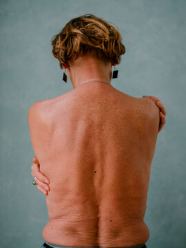 Senior female naked back looking down