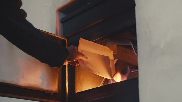 Burning old papers or documents in fireplace, old good times concept, closeup view