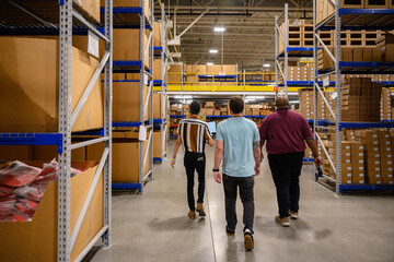 Manager walking with employees in warehouse 