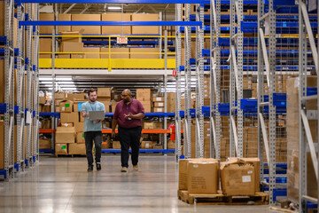 Manager walking with employee in warehouse 