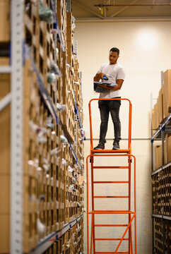 E-Commerce Warehouse worker checking box with scanner 