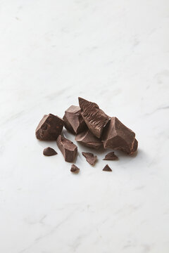 Chunks of dark chocolate on marble background