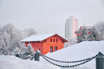 Park of Culture and Recreation, Intourist Hotel and the Museum of Local Lore of Khabarovsk, Russia, after a heavy snowfall in the morning at dawn. Trees in the snow.