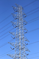 High voltage tower with power lines. Bottom view of high voltage pole power transmission tower with blue sky