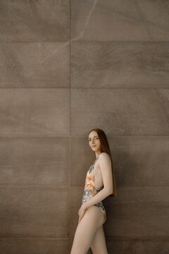young female posing in swimsuit on neutral background