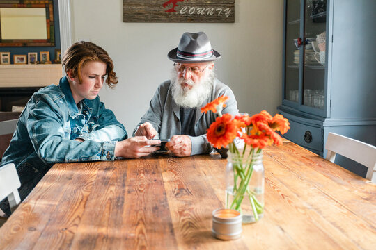 Senior man using his grandson's smartphone at home