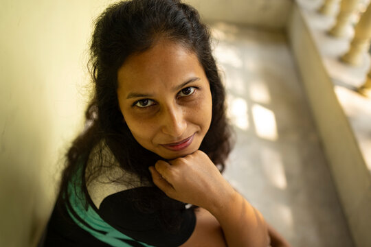 Woman smiling and looking at camera sit on varandah