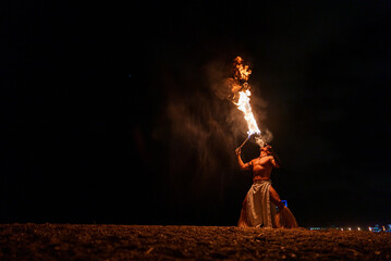 performer blowing on burning fire