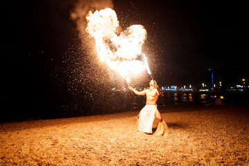 tribal showman breathes fire from his mouth