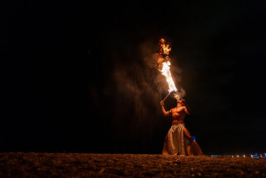 performer blowing on burning fire