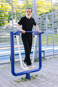 Aged man working out with elliptical equipment 