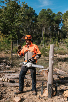 Lumberjack with chainsaw explaining work process