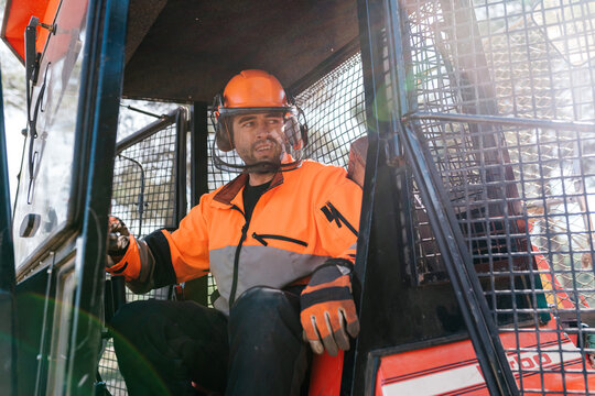 Male lumberjack in tractor in forest