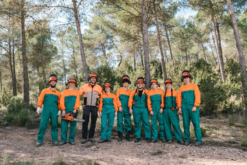Positive team of woodcutters in woods