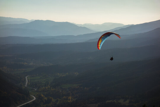 colourful tandem paraglider wing in smokey mountains