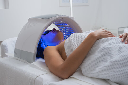 Woman Lying Under A LED Light Therapy Lamp