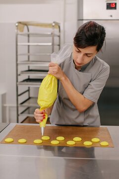 Woman pouring cookies from pastry bag 