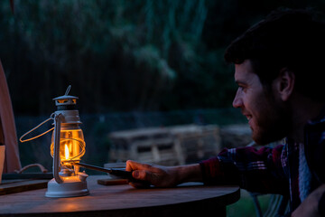 Man lighting oil lamp at night