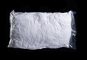 white pillow in plastic bag  on black background