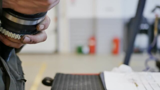 The auto repairer pumps generous grease into the new front CV joint before installing it in the vehicle. Repair car maintenance. Close up, DOF