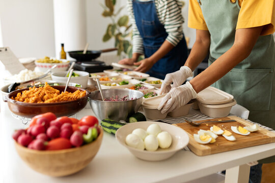 Cooks preparing food on lunch boxes to delivery