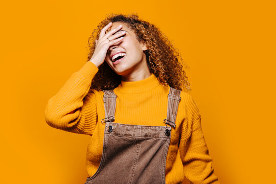 Cheerful teen girl laughing with hand on face