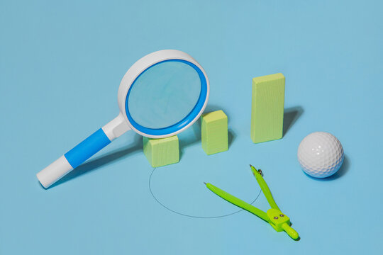 A magnifying glass lying on columns of different height