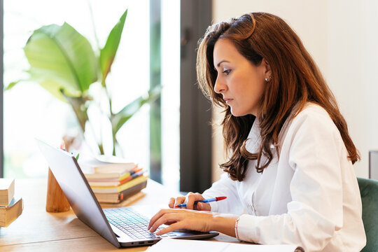 Serious Hispanic researcher typing on laptop