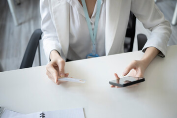 Cropped shot businesswoman holding credit card and making banking online on her smart phone.