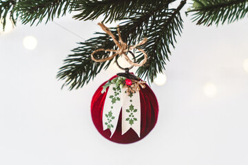 Classic red christmas ornament hanging on a pine tree branch