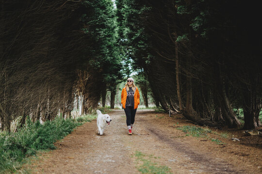 Woman walking in forest with dog