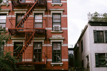 Fototapeta na wymiar Typical facades of New York City. Brown brick houses in NYC, USA. Urban architecture