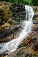 Obraz premium Beautiful Andahelena Ella waterfall in Elpitiya, Sri Lanka. Water stream cascaded through wet mossy rocks, surrounded by lush greenery in the tropical rain forest.