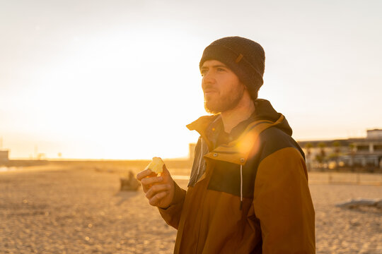 Portrait of pensive man at beach during sunset