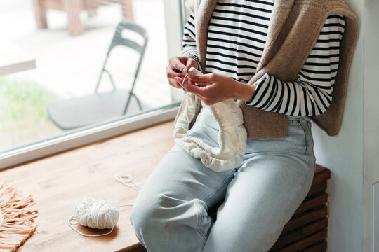 Woman knits in cafe.