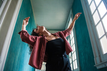 Joyful woman dancing at hallway at home