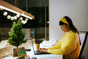 Asian designer during laptop in evening
